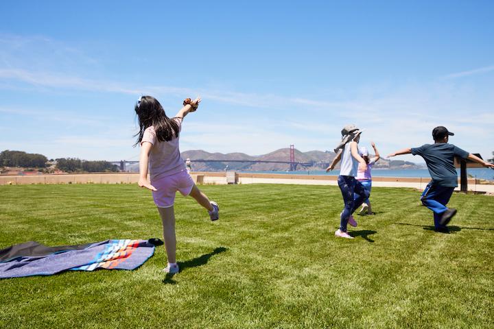 Three children playing on a lawn at Presidio Tunnel Tops. Photo by Rachel Styer.