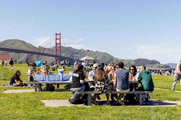 A large group gathers at two picnic tables at the West Bluff Picnic Area. Photo by Myleen Hollero.
