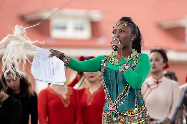 Emcee speaks into a microphone as part of World Arts West’s Dances in the Park in the Presidio.