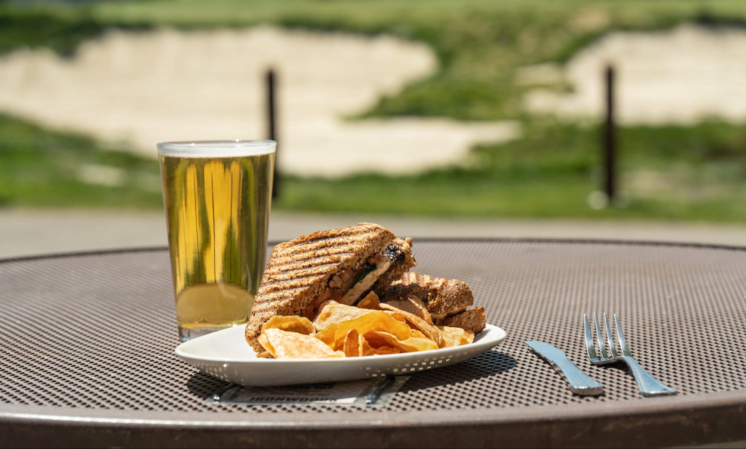 Image of a beer and a plate of food in front of the Presidio Golf Course.