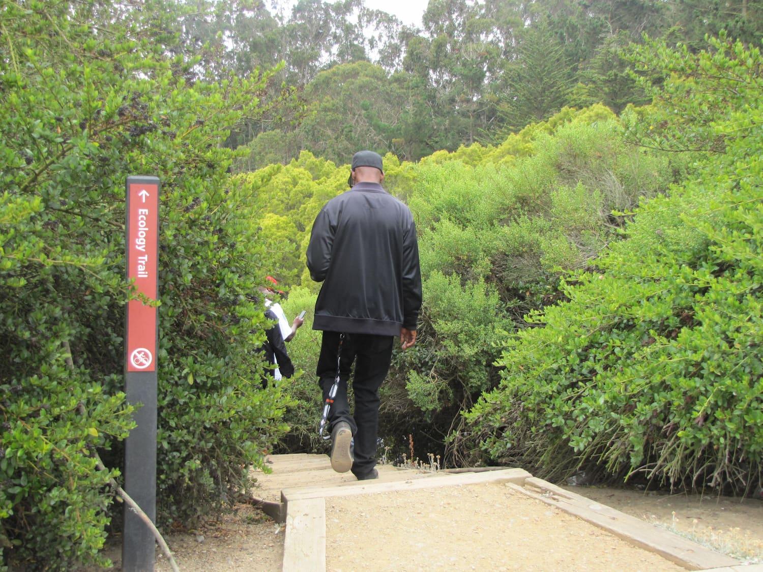 Man enters the southern trailhead for the Ecology Trail at Inspiration Point.