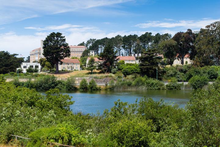 image of a small pond with historic homes for rent in the background.