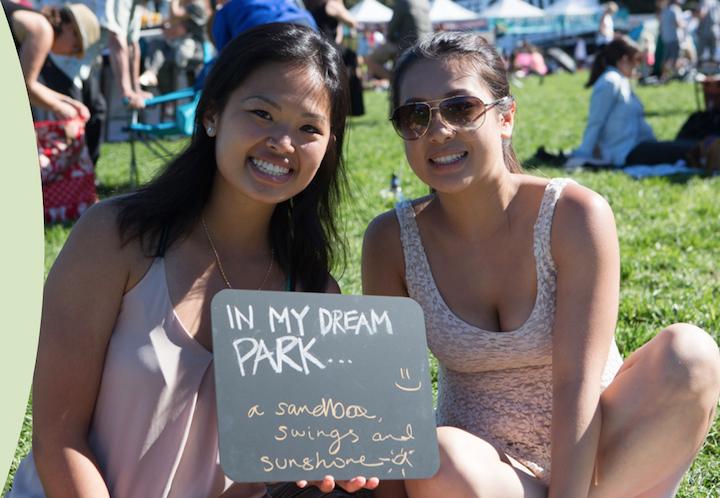Two women hold a sign on the Presidio lawn.