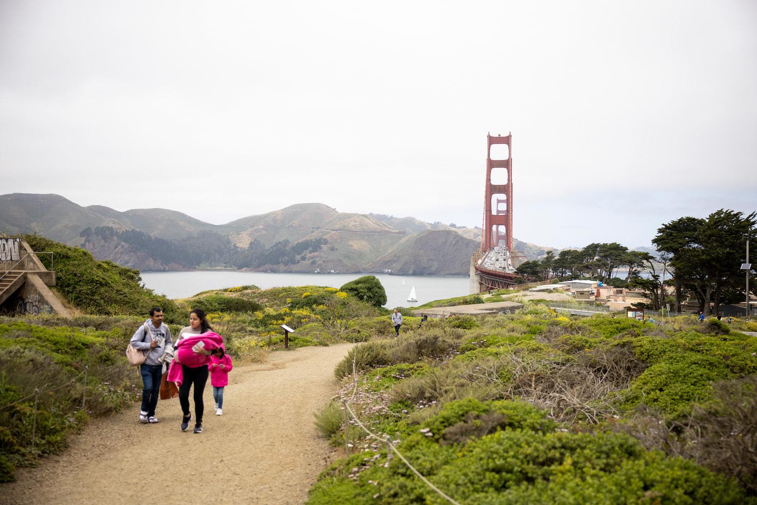 Photo of a family on the dirt path near along the California Coastal Trail near the Golden Gate Bridge and the Batteries.
