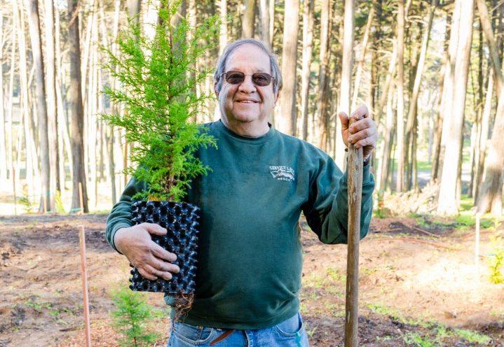 Peter Ehrlich holding a tree.