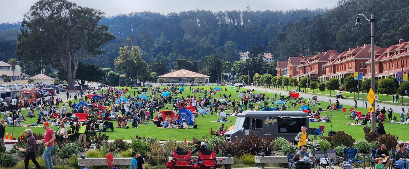 Large group of people picnicking on Presidio Main post lawn on a busy day